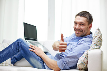 Image showing smiling man working with laptop at home