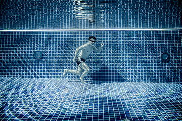 Image showing Man runs underwater swimming pool