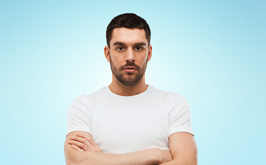 Image showing young man with crossed arms over blue background