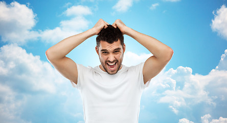 Image showing crazy shouting man in t-shirt over blue sky