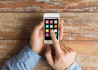 Image showing close up of male hands with smartphone on table