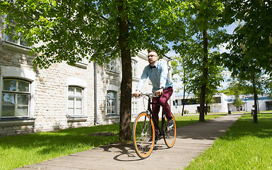 Image showing happy young hipster man riding fixed gear bike