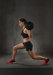 Image showing young woman flexing muscles with barbell in gym