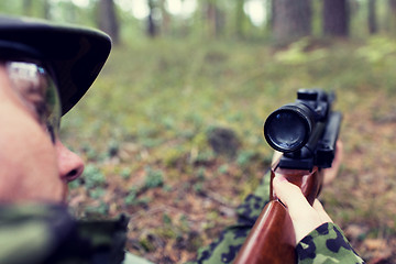 Image showing close up of soldier or hunter with gun in forest