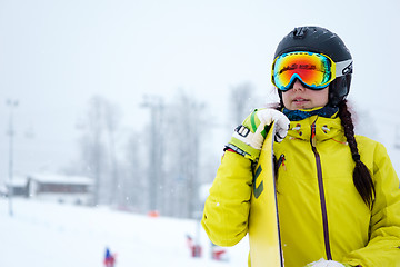 Image showing Female snowboarder standing with snowboard