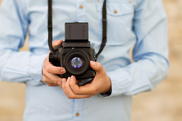 Image showing close up of hipster man with film camera in city
