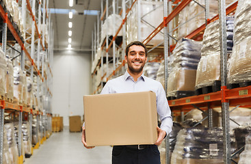 Image showing happy man with cardboard parcel box at warehouse