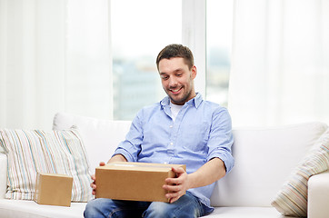 Image showing happy man with cardboard boxes or parcels at home