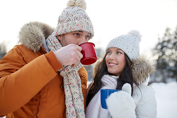 Image showing happy couple with tea cups over winter landscape