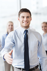 Image showing smiling businessman making handshake in office