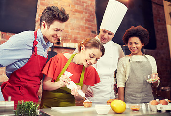 Image showing happy friends and chef cook baking in kitchen