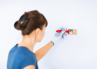 Image showing woman with paintbrush colouring the wall