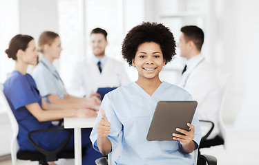 Image showing happy doctor with tablet pc over team at clinic