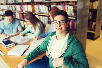 Image showing happy student boy reading books in library