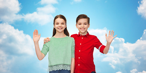 Image showing happy boy and girl waving hand