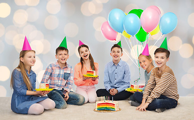 Image showing happy children in party hats with birthday cake