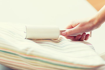 Image showing close up of woman hand with sticky roller cleaning