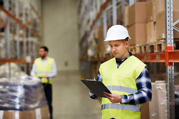 Image showing man with clipboard in safety vest at warehouse