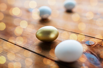 Image showing close up of golden and white easter eggs on wood