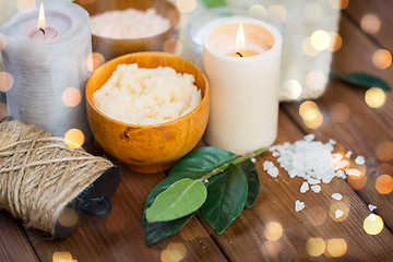 Image showing close up of natural body scrub and candles on wood