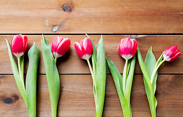 Image showing close up of red tulip flowers on wooden table