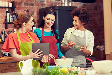 Image showing happy women with tablet pc cooking in kitchen