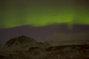 Image showing Northern lights with snowy mountains in the foreground