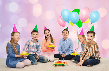 Image showing happy children in party hats with birthday cake