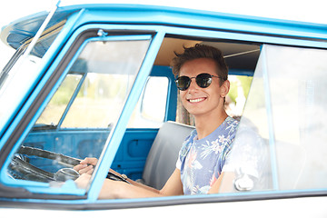 Image showing smiling young hippie man driving minivan car