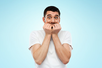 Image showing scared man in white t-shirt over blue background