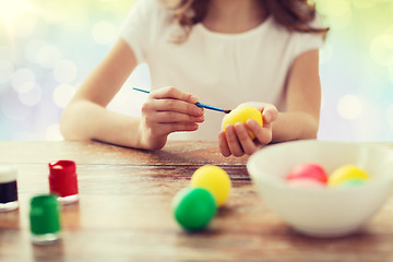 Image showing close up of girl with brush coloring easter eggs