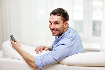 Image showing happy man with smartphone at home