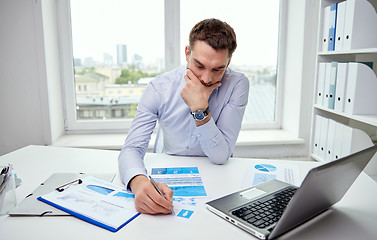 Image showing stressed businessman with papers in office