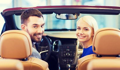 Image showing happy couple sitting in car at auto show or salon