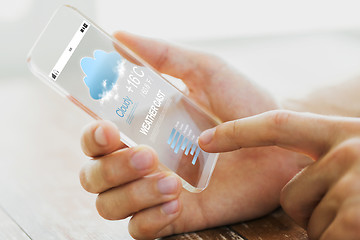 Image showing close up of male hand with weather cast smartphone