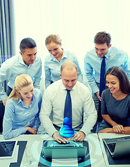 Image showing smiling business people with laptop in office