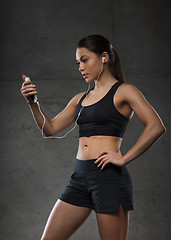 Image showing woman with smartphone and earphones in gym