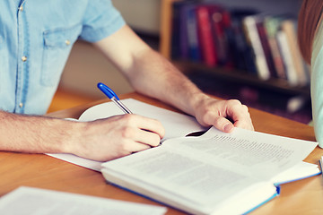 Image showing close up of student hands writing to notebook