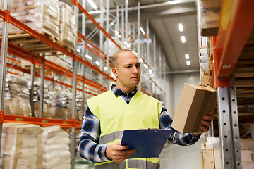 Image showing man with clipboard in safety vest at warehouse