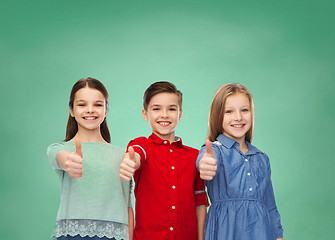 Image showing happy children showing thumbs up over green board