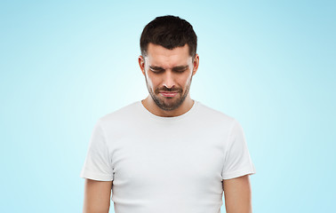 Image showing unhappy young man over blue background