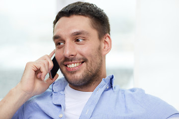 Image showing happy man calling on smartphone at home