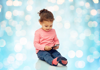 Image showing smiling little baby girl playing with smartphone