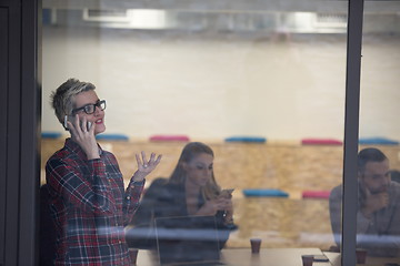 Image showing business woman in meeting room  speaking by cell phone