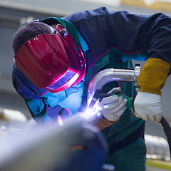 Image showing Industrial worker welding in metal factory.