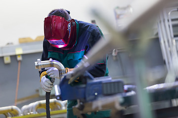 Image showing Industrial worker welding in metal factory.