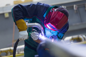 Image showing Industrial worker welding in metal factory.