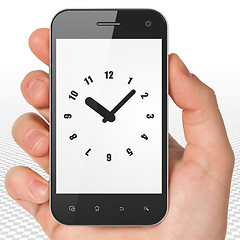 Image showing Time concept: Hand Holding Smartphone with Clock on display