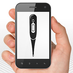 Image showing Medicine concept: Hand Holding Smartphone with Thermometer on display