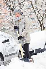 Image showing Independent woman shoveling snow in winter.